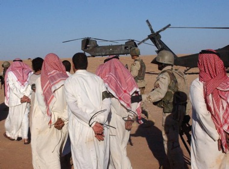 Suspected al-Qaeda terrorists escorted to a POW camp.